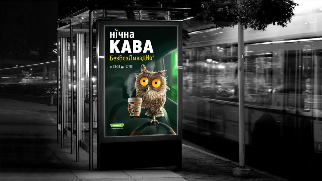 OKKO free night coffee poster with an owl at a city bus stop