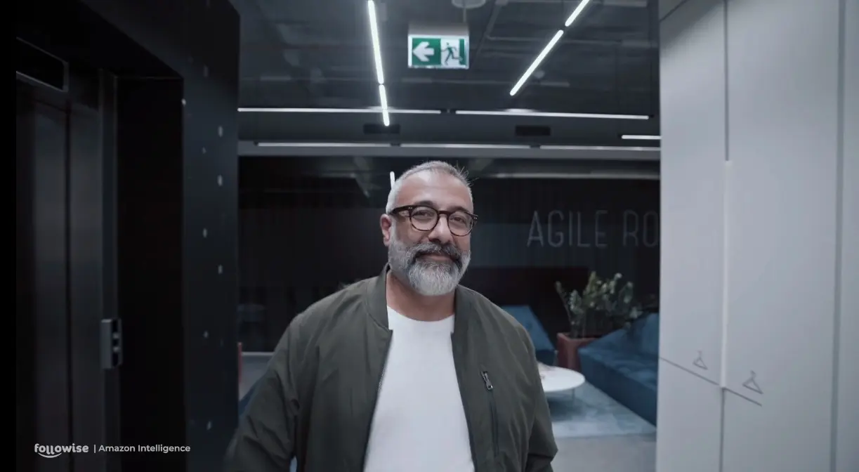 Amazon Intelligence video still of a bearded man in glasses in an office