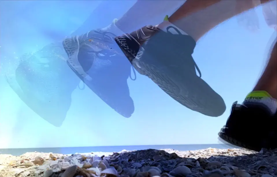 Nova Poshta campaign video still: a courier's sneaker stepping on a pebble beach