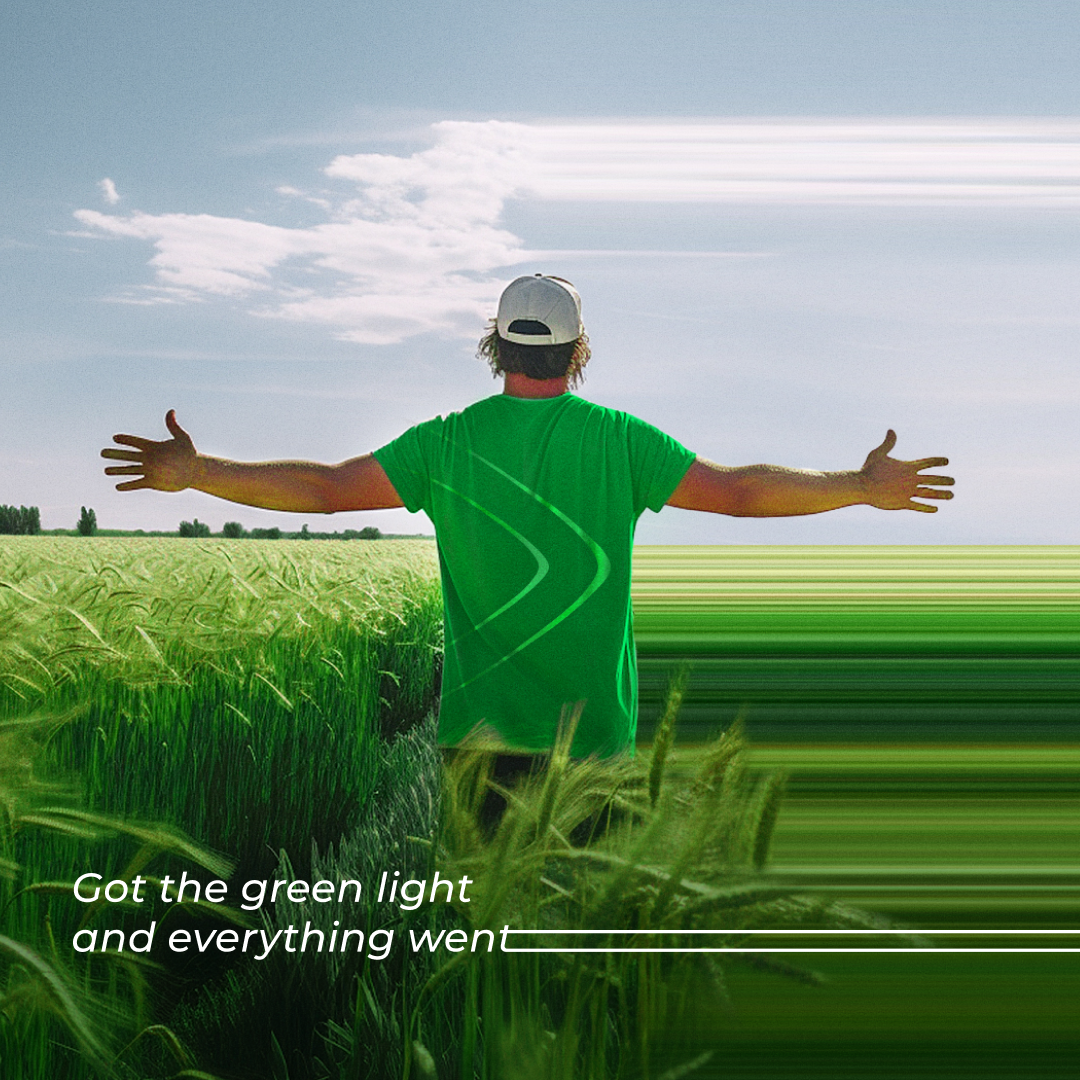 Farmer with outstretched arms in a wheat field, Invest Office slogan Got the green light