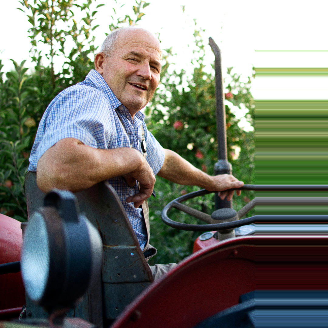 Smiling farmer on a red tractor in an orchard for the Invest Office campaign
