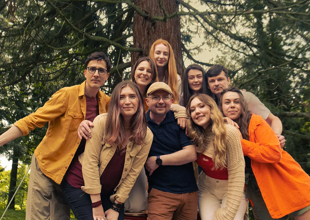 Bambuk Studio team posing together outdoors by a large tree