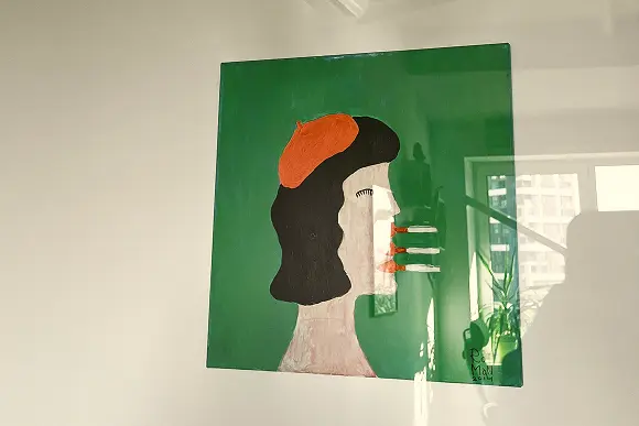 Green abstract portrait artwork hanging on an office wall